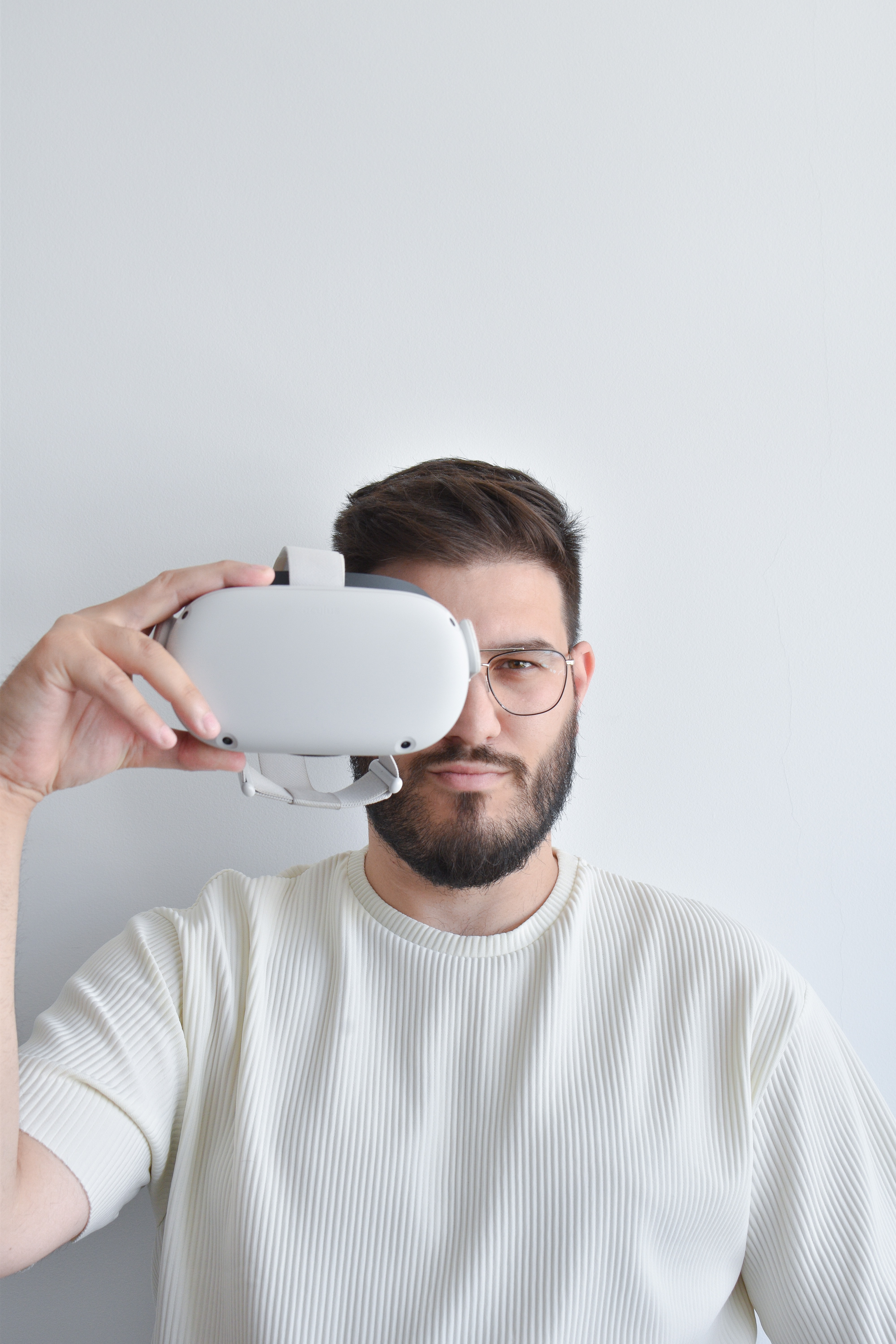 man holding VR headset up to face in front of white background