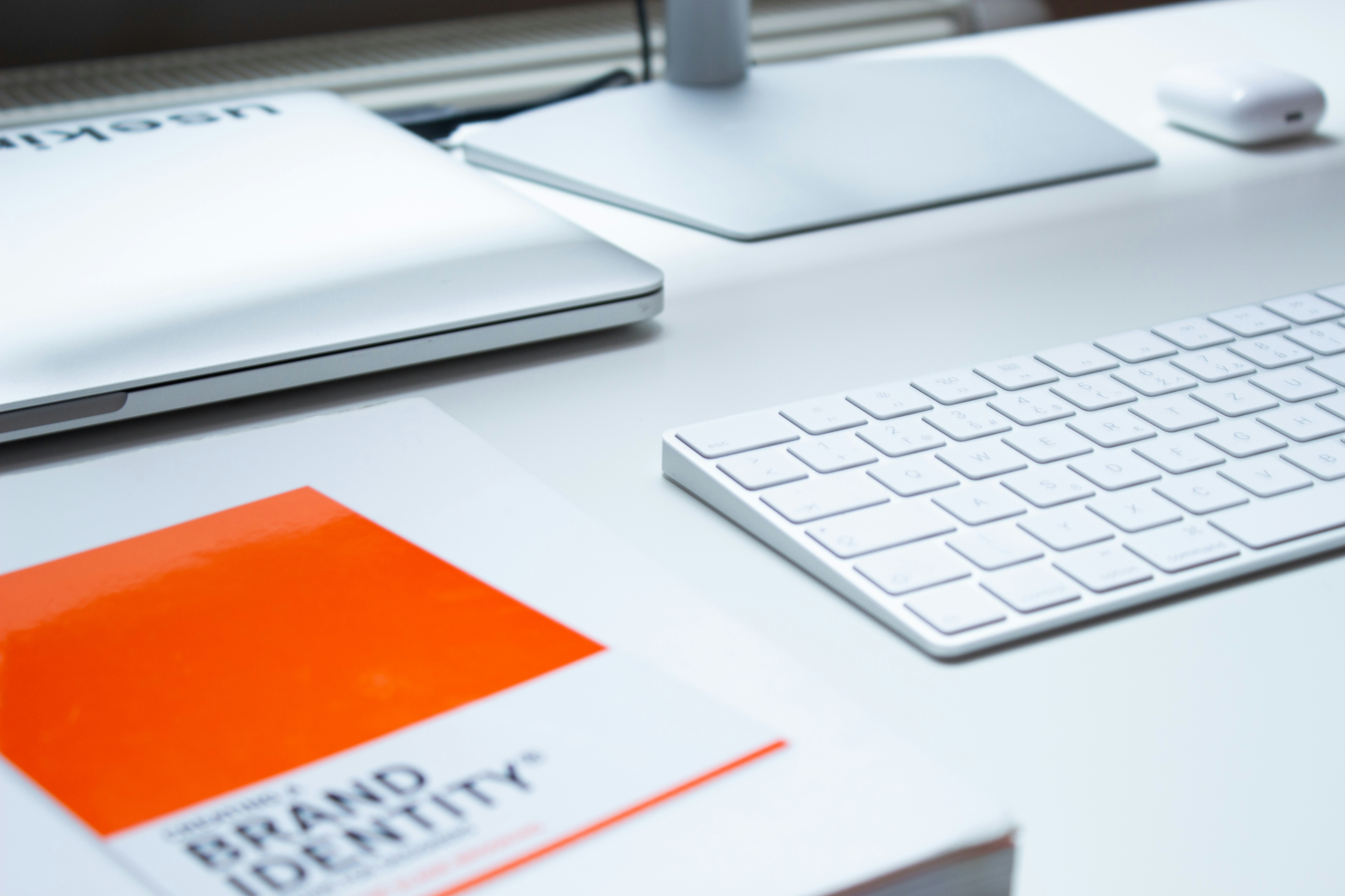 brand identity book next to computer on white desk